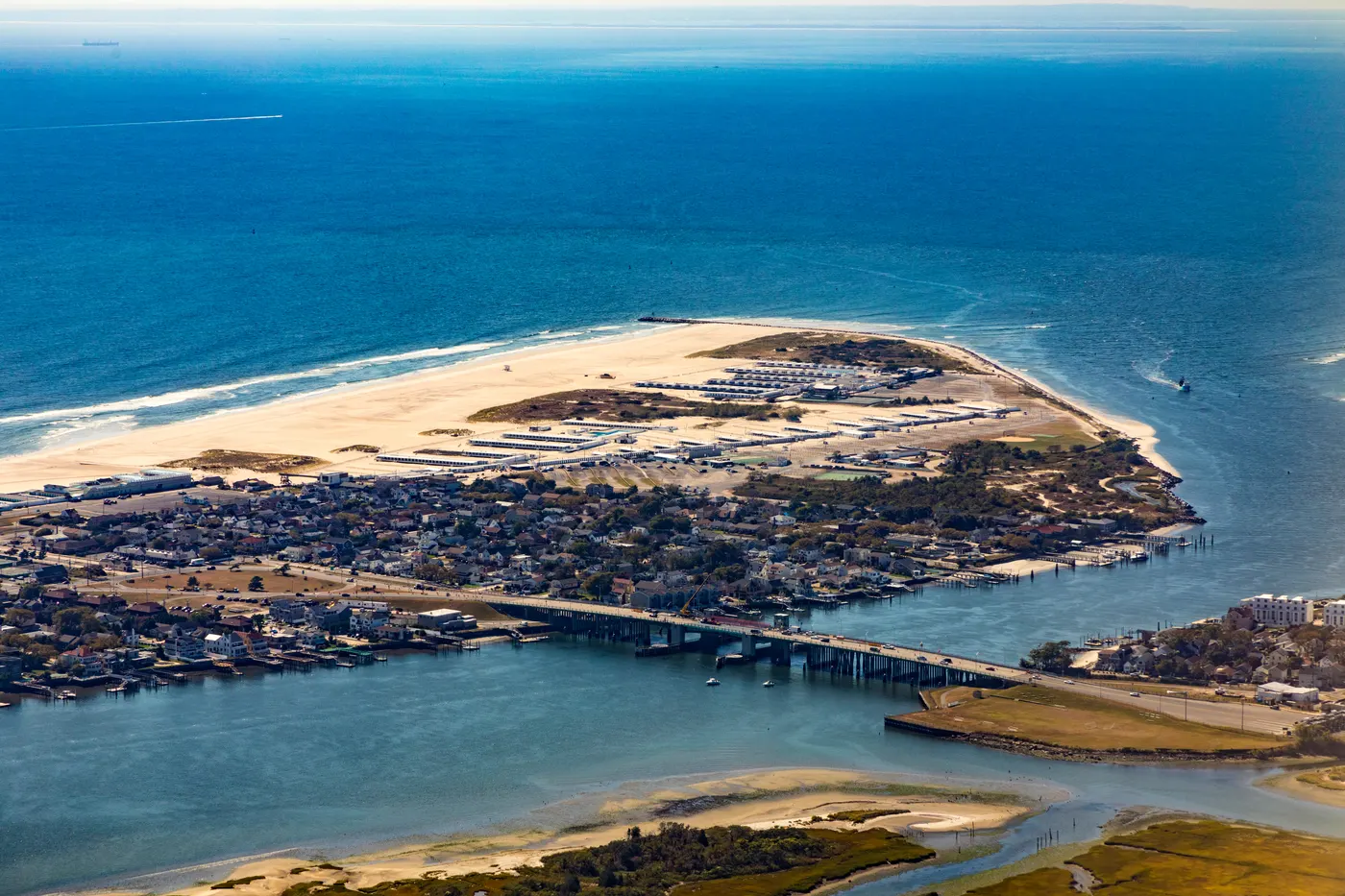 Aerial view of a barrier island tip on the Atlantic coast near New York, with a bridge crossing the inlet