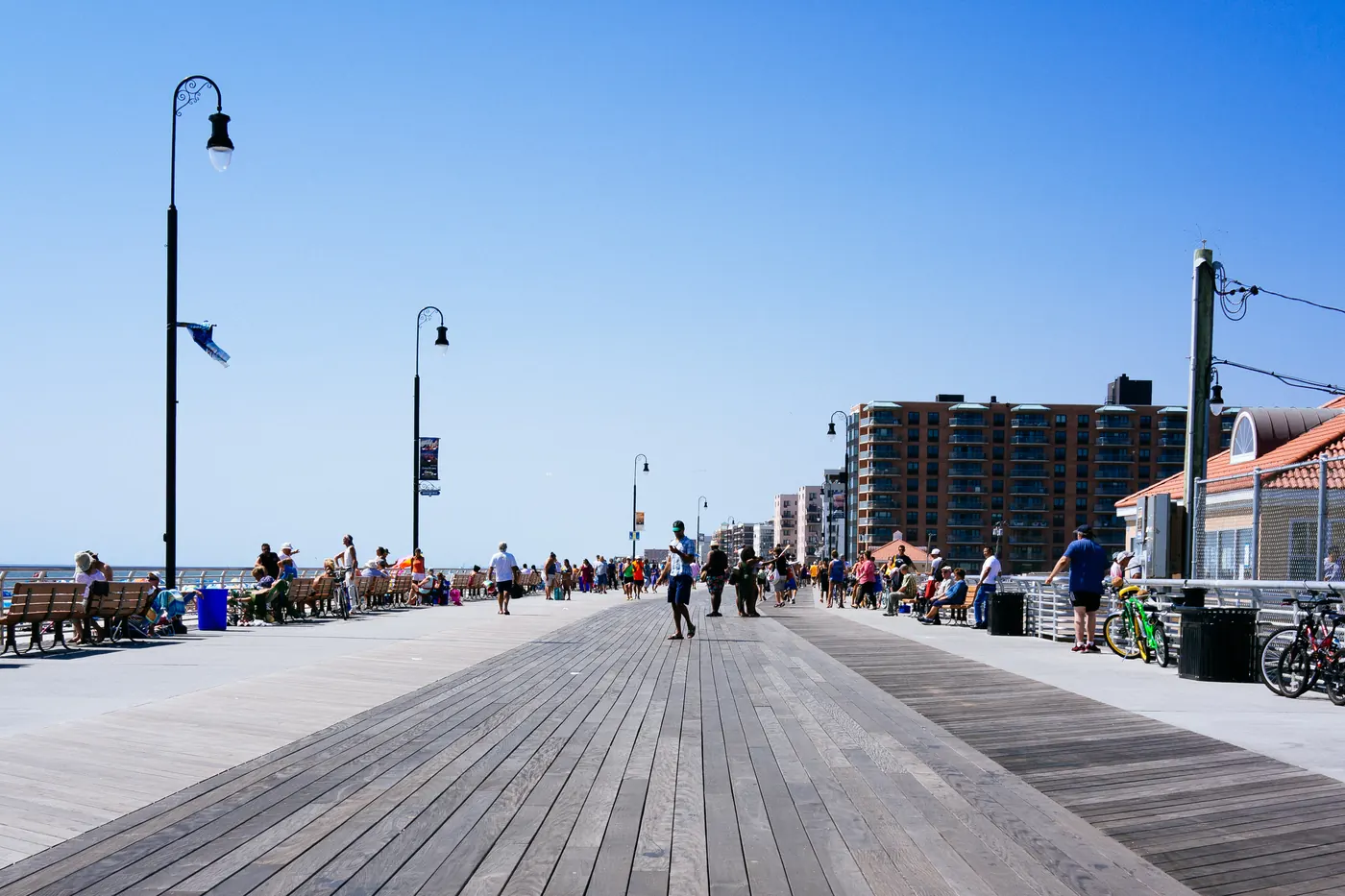 The Long Beach, NY boardwalk on a summer day, with beachfront buildings along the shore