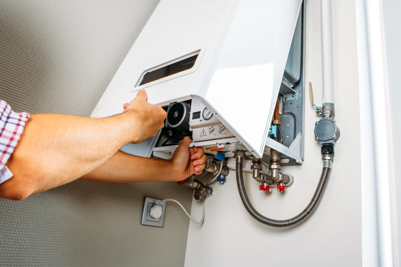 Technician servicing the internals of a residential water heating unit
